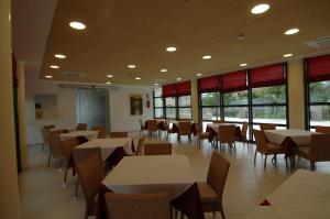 a dining room with tables and chairs and windows at Elaia Garden Hotel in Sperlonga