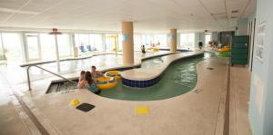 Holiday Sands at South Beach في ميرتل بيتش: حمام سباحة داخلي كبير مع وجود أشخاص في الماء