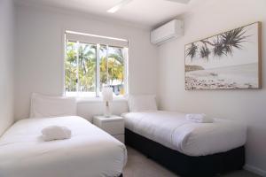 Un pat sau paturi într-o cameră la Coral Beach Noosa Resort +46 fotografii