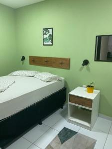 Un dormitorio con una cama y una mesita de noche. en Loft Dominguinhos, en Campina Grande