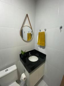 Un baño con lavabo, espejo e inodoro. en Loft Dominguinhos, en Campina Grande 9 fotos más