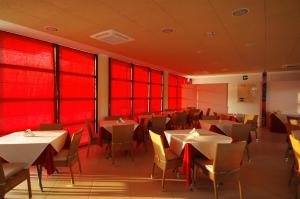 a restaurant with red walls and tables and chairs at Elaia Garden Hotel in Sperlonga