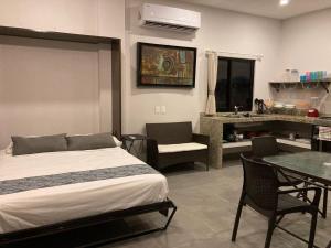 a bedroom with a bed and a table and a kitchen at Hotel Playa Azul Sayulita in Sayulita