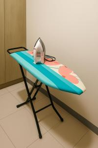 a table with a surfboard and a machine on it at Queen room only near sm mall Fast Wifi in Malabañas