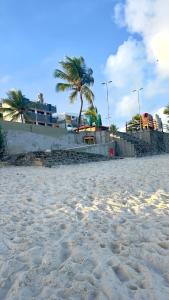a sandy beach with palm trees in the background at Flat Barra Beach in Barra de São Miguel