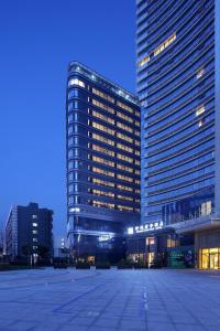 a large building with a parking lot in front of it at SSAW Boutique Hotel Hangzhou Wildwind in Hangzhou