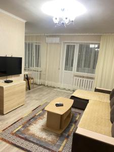 a large living room with a tv and a couch at 2кмн Квартира по проспекту Республики 8 in Astana +7 photos