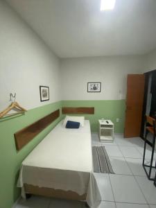 Un dormitorio con una cama grande con una pared verde. en Loft Jackson do Pandeiro, en Campina Grande