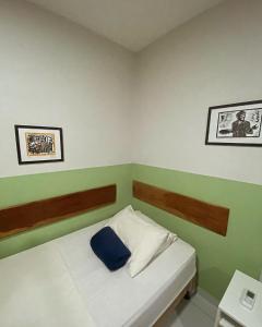 Un dormitorio pequeño con una cama con una almohada azul. en Loft Jackson do Pandeiro, en Campina Grande