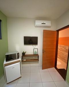 Habitación con microondas y TV en la pared. en Loft Jackson do Pandeiro, en Campina Grande 8 fotos más