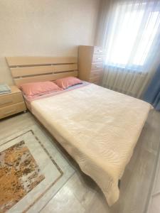 a bedroom with a large bed with a window at 2кмн Квартира по проспекту Республики 8 in Astana