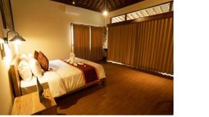 Un dormitorio con una cama y una ventana grande. en Villa Pondok Sadia, en Tegalalang
