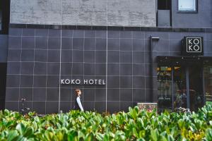 Un maniquí de pie frente a un edificio del hotel Koko. en KOKO HOTEL Osaka Namba Sennichimae, en Osaka