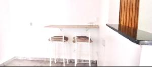 a white table with two chairs under a counter at Ap espaçoso prox aeroporto in Manaus