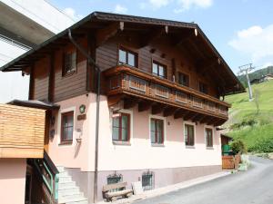uma grande casa de madeira com uma varanda em Chalet in Dienten on Hochkönig Ski Slopes, cleaning included em Dienten am Hochkönig
