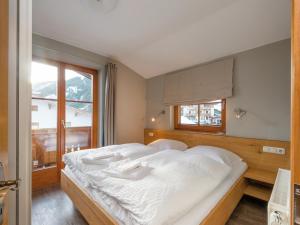 um quarto com uma grande cama branca com janela em Chalet in Dienten on Hochkönig Ski Slopes, cleaning included em Dienten am Hochkönig