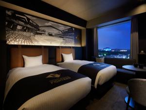 北广岛ES CON FIELD HOKKAIDO HOTEL Kitahiroshima Station的一间有两张床和一幅棒球壁画的酒店房间