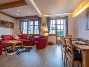 ein Wohnzimmer mit einem roten Sofa und einem Tisch in der Unterkunft Alpine Apartment near Kaprun, cleaning included in Dürnberg