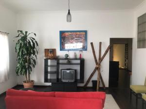 a living room with a red couch and a tv at Centro Histórico Inolvidable Puebla in Puebla