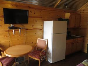 a kitchen with a small table and a refrigerator at All Tucked Inn Cabins in Stockdale