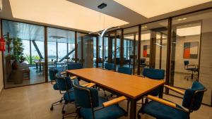 a conference room with a wooden table and blue chairs at Studio Beira-mar, rooftop com piscina e jacuzzi in Fortaleza +57 photos