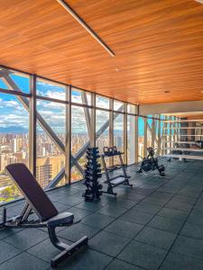 a gym with cardio equipment in a building with windows at Studio Beira-mar, rooftop com piscina e jacuzzi in Fortaleza