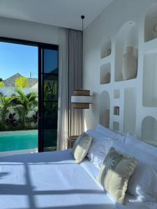 a bedroom with a bed with a view of a pool at White Shell Villas in Uluwatu