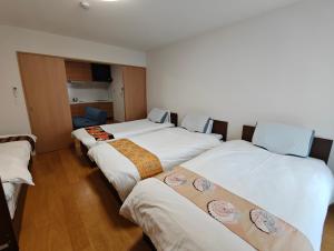 un grupo de cuatro camas en una habitación en Shin-Imamiya Grand F, en Osaka