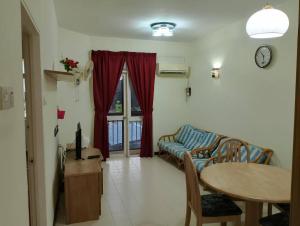 バトゥ・フェリンギにあるHome stay Bayu Emas Appartment, Batu Ferringhiのソファとテーブルのあるリビングルーム