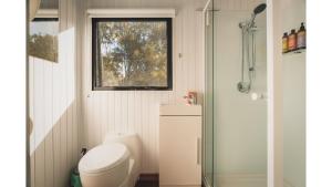 a small bathroom with a toilet and a window at Mirror Reflections by Tiny Away in Tamborine
