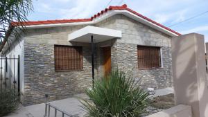 a small brick house with an umbrella in front of it at Casa a 800 mts de pleno centro - NO RECIBO GRUPO DE JOVENES in Villa Carlos Paz