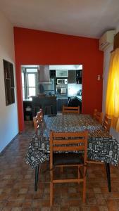 a dining room with a table and chairs and a kitchen at Casa a 800 mts de pleno centro - NO RECIBO GRUPO DE JOVENES in Villa Carlos Paz +8 photos