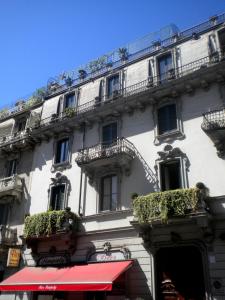 a large white building with balconies and plants on it at Lepetit Milano in Milan