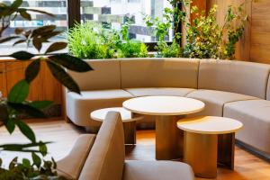 a couch and two tables in a room with plants at JR-East Hotel Mets Shibuya in Tokyo +48 photos