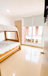 a bedroom with a bunk bed and a large window at Casa frente al mar con piscina in Coveñas +22 photos