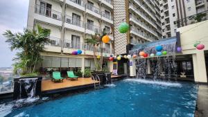 a pool in the middle of a building with a fountain at Golden Tulip Essential Tangerang in Tangerang