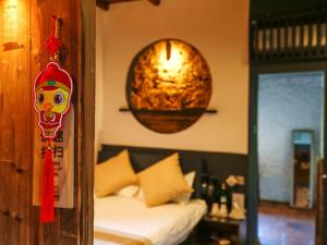 מיטה או מיטות בחדר ב-Tulou Herongzhuang Inn