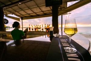 a glass of wine sitting on a table at a bar at Chaweng Buri Resort in Chaweng