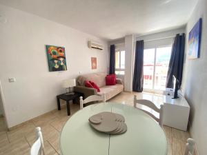 a living room with a table and a couch at Panoramic Views Cozy Apt Benalmádena Center in Benalmádena