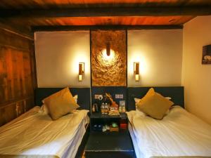 מיטה או מיטות בחדר ב-Tulou Herongzhuang Inn