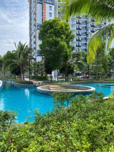 a swimming pool with blue water in a city at EMAS Suite Timurbay, Kuantan in Kuantan