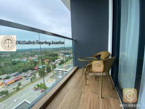 a balcony with a table and chairs and a view of a city at EMAS Suite Timurbay, Kuantan in Kuantan +1 photo