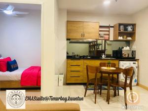 a kitchen and dining room with a table and a bed at EMAS Suite Timurbay, Kuantan in Kuantan