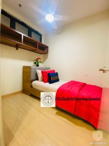 a bedroom with a bed with a red blanket at EMAS Suite Timurbay, Kuantan in Kuantan