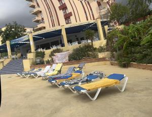 a row of beach chairs sitting in front of a building at Panoramic Views Cozy Apt Benalmádena Center in Benalmádena