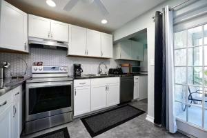 een keuken met witte kasten en roestvrijstalen apparaten bij Villa On The Ocean in Fort Pierce