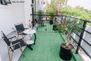 a balcony with a table and chairs and a plant at Blue Sea Hotel in Cam Lâm