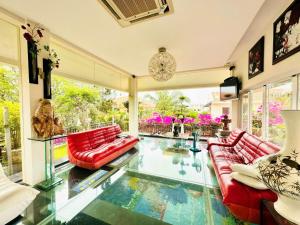 un soggiorno con divani rossi e pavimento in vetro di Green Villa Hồ Bơi riêng a Phan Thiet