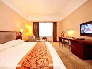 a hotel room with a large bed and a flat screen tv at Fujian Galaxy Garden Hotel in Fuzhou +199 photos