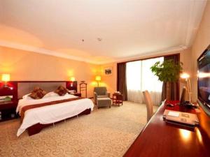 a hotel room with a bed and a television at Fujian Galaxy Garden Hotel in Fuzhou